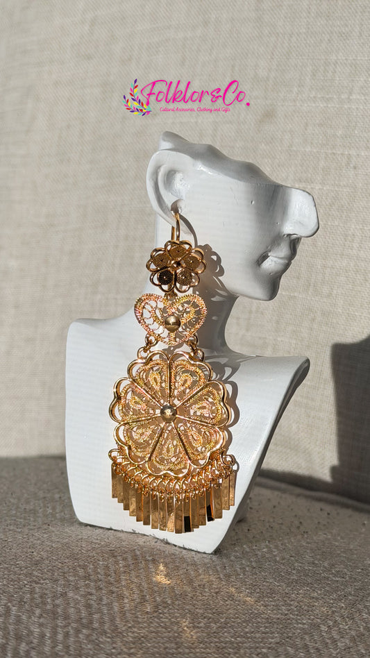 Gold earrings on a mannequin ear with 'Folkloryco' branding