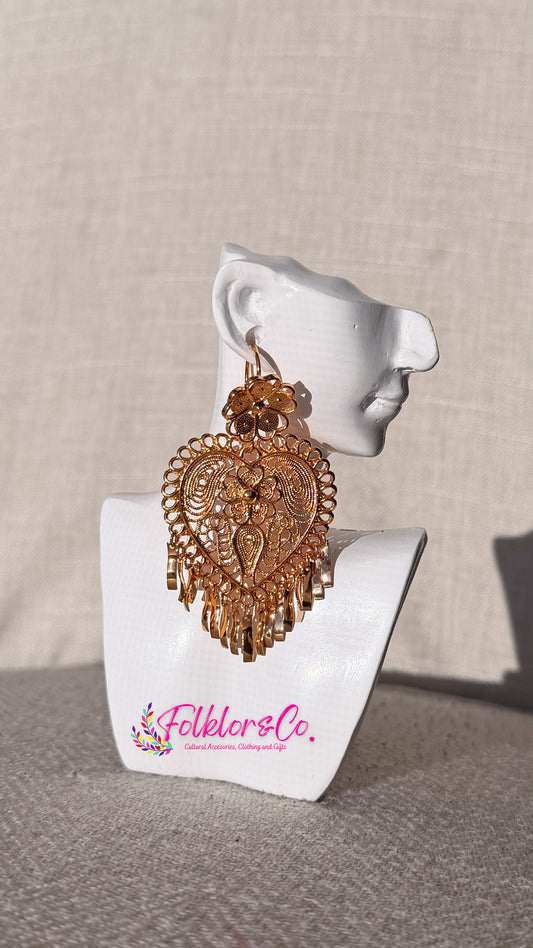 Gold heart-shaped Mexican filigrana earrings on a white mannequin ear with 'Folkloryco' branding.