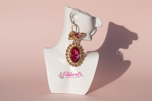 Mexican gold earring with pink gemstone on a white mannequin bust with 'Folkloryco' branding.