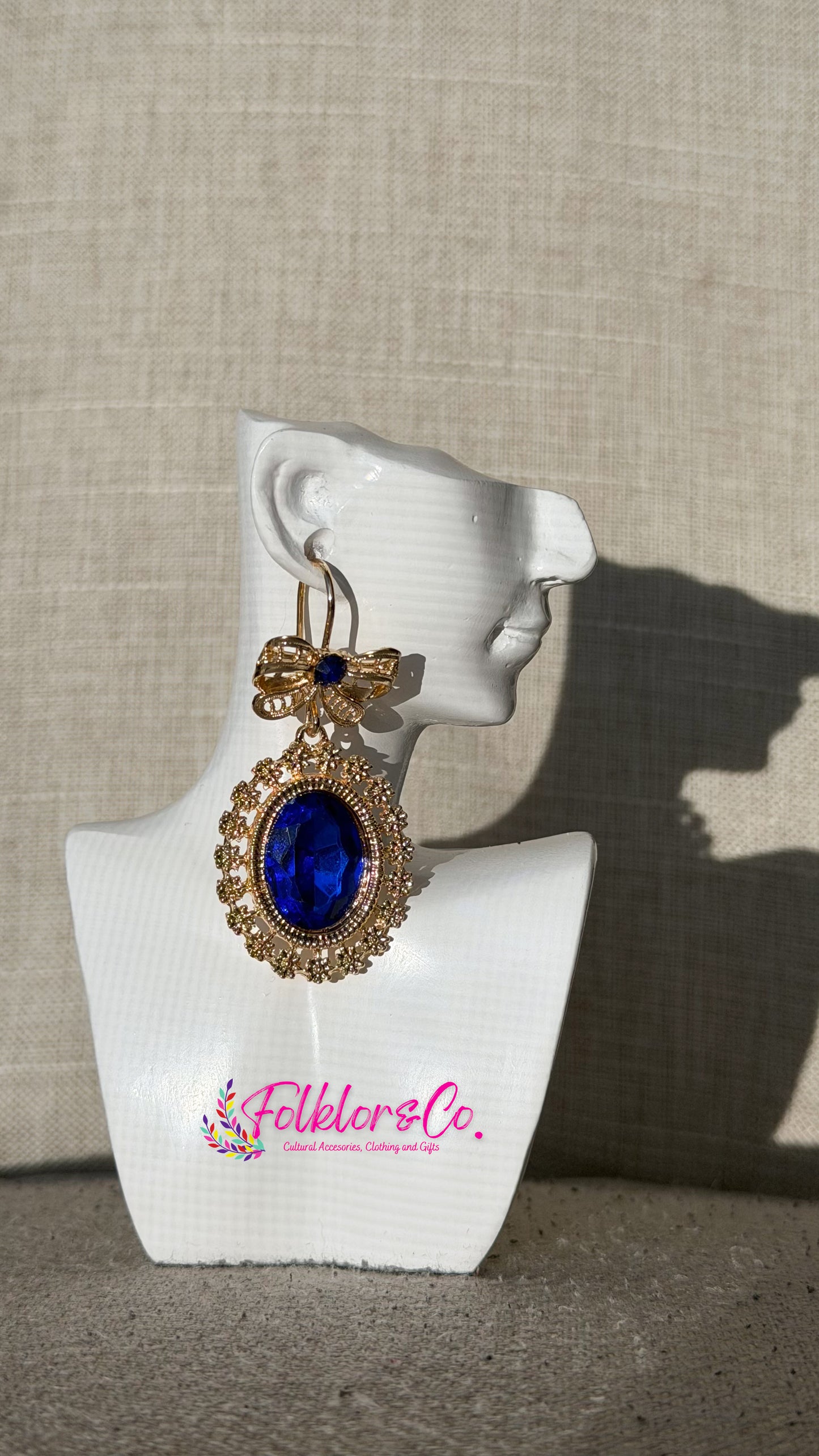 Traditional Mexican filigrana earring on a white mannequin ear with 'Folkloryco’ branding against a beige background