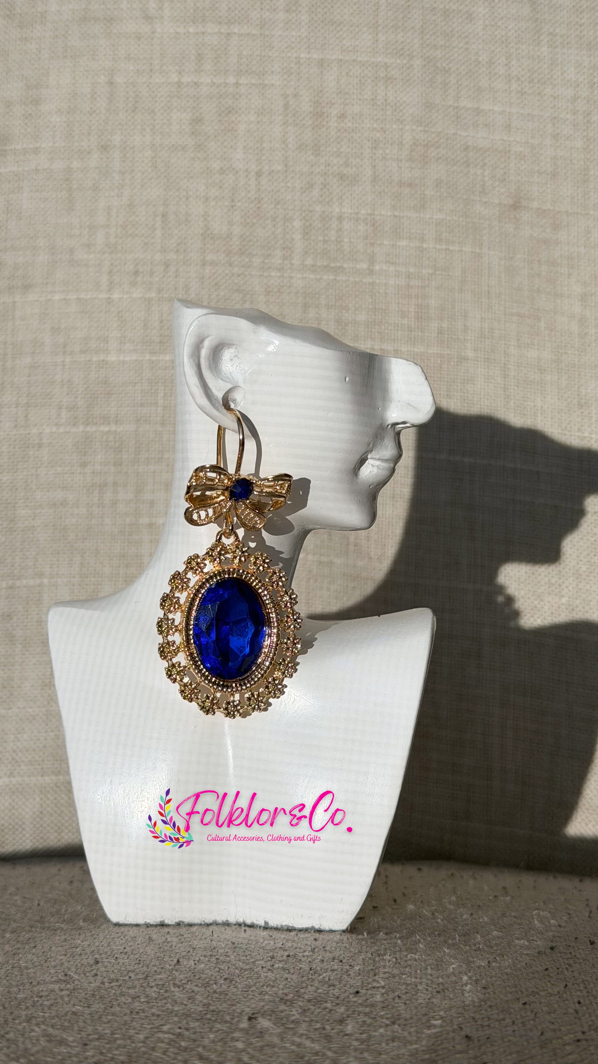 Traditional Mexican filigrana earring on a white mannequin ear with 'Folkloryco’ branding against a beige background