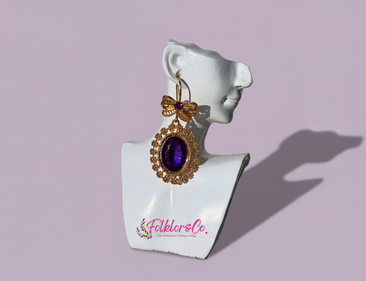 Mexican gold earring with purple gemstone on a white mannequin bust with 'Folkloryco' branding.